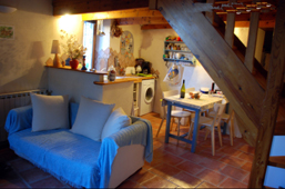 Location gte en Cvennes. Le coin cuisine/repas dans un angle du sjour, sous la mezzanine